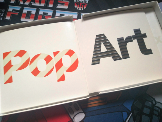 Interior of the box. When opened up, it contains three cardboard sleeves, "Pop", "Art" and (not pictured) "Mix", each with the title presented using a different texture effect.