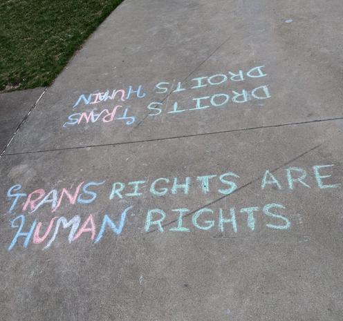 Two pieces of chalk words on a concrete sidewalk

TRANS RIGHTS ARE HUMAN RIGHTS

DROITS TRANS DROITS HUMAIN