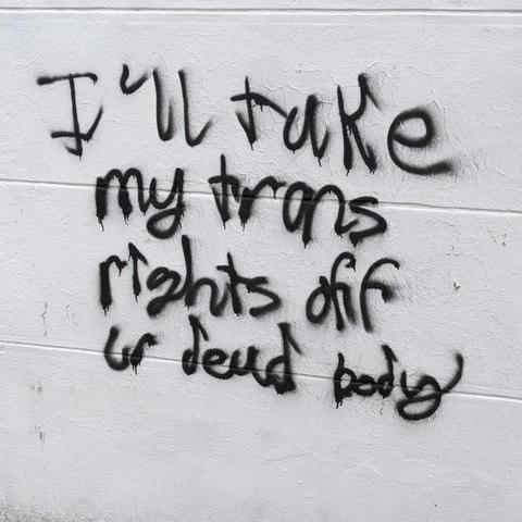 Words spray painted on a white wall

I'LL TAKE MY TRANS RIGHTS OFF UR DEAD BODY