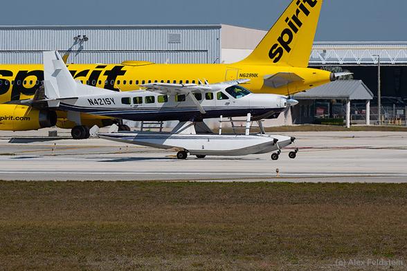 Cessna 208 Caravan on floats taking off from Ft. Lauderdale on a sunny day with a Spirit Airbus behind, awaiting his turn.