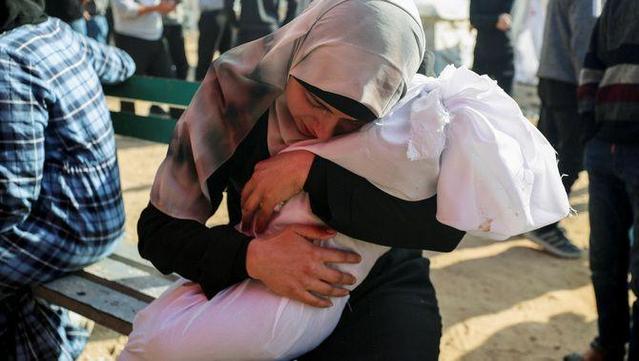 Una dona abraça el cadàver d'un infant mort en un bombardeig israelià a Beit Lahia, al nord de la Franja, el 28 d'abril (Reuters/Mahmoud Issa)