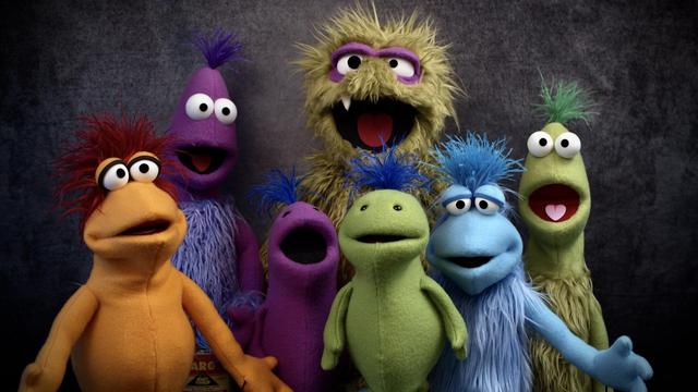 Seven puppets made by Kevin in 2021, two Smols (purple and green), two Greeblees (blue and orange), two Nurnees (purple and green) and a green furry monster