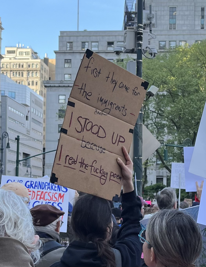 A sign that says “When they came for the immigrants, I STOOD UP because I read the fucking poem!”