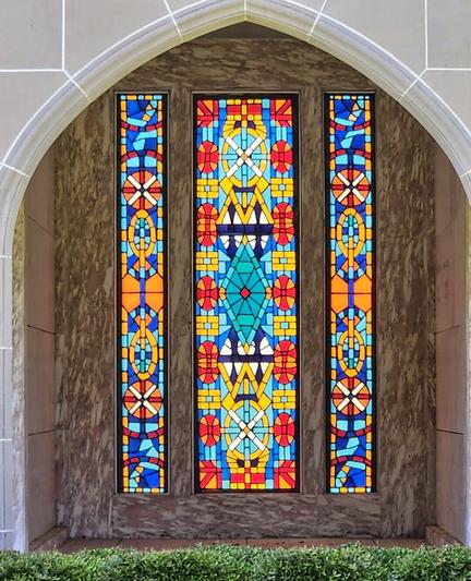 Ornate archway with brightly colored stained glass windows within an alcove.
