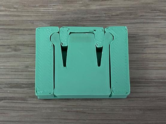 A three-piece assembly.  The largest piece has a rectangular slot open on both ends.  The medium size piece slides in from the front.  It has two springy arms that lock into detents in the slot wall.  The small, U-shaped piece slides in from the back and forces the springy pieces into the divot.