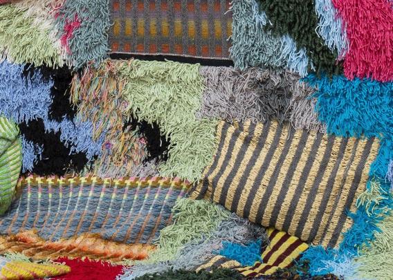 a detail of a textile sculpture showing numerous textures and colors with many fiber ends