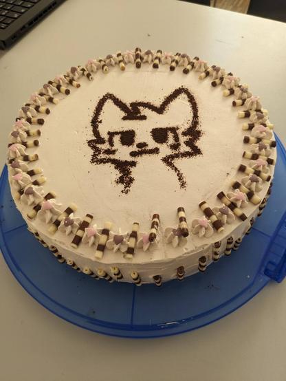 A Malakoff cake with chocolate dust in the shape of a boykisser on it
