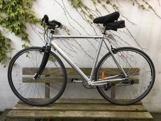 Side picture of the same bicycle, with a more, small prominent under-seat bag.