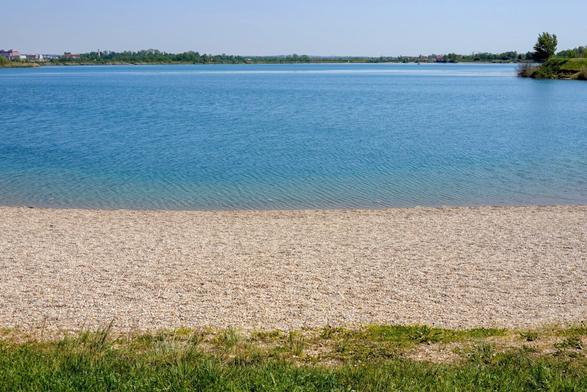 Shore of a lake covered with small pebbles.