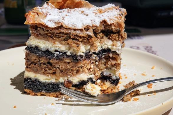 Cake with several layers of poppy seeds, cottage cheese, dough, apples and walnuts.