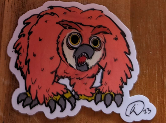 A sticker of Charlie the owlbear from the Love and Hex comic, looking cute/terrifying.