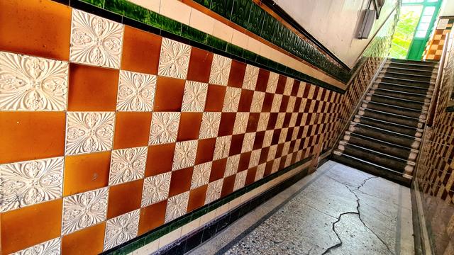 The communal stairwell in a Glasgow tenement lined with decorative tiles.