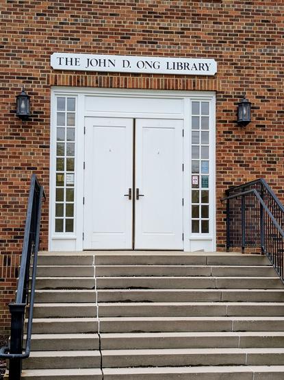 Entrance door to a school library reads ”The John D. Ong Library.”