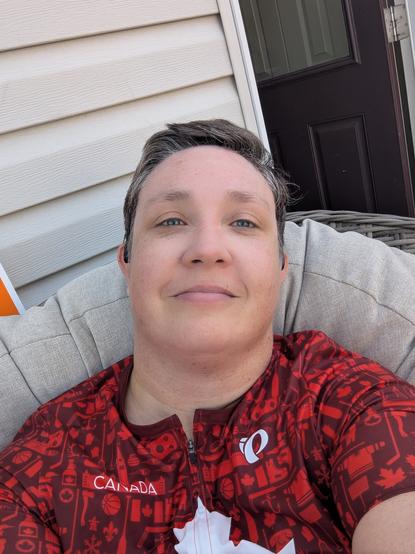 An exhausted and sweaty Canadian trying to not look goofy in a selfie while sitting on a nest chair in a sunroom
