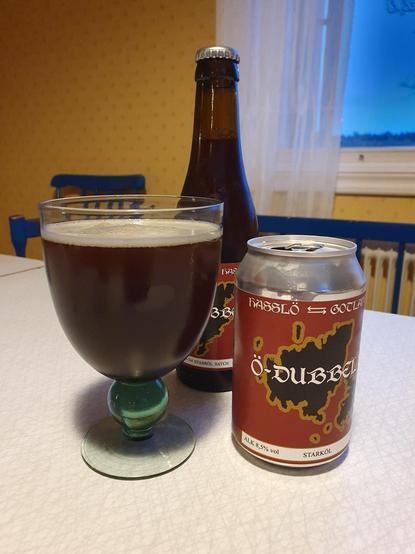 En kupa med mörkt öl bredvid Öbrygds burk.
