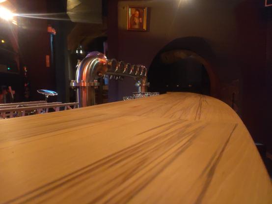 Eine Holztheke  und eine Zapfanlage aus Edelstahl.