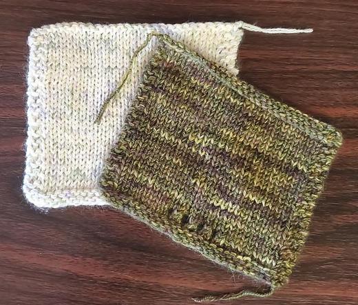A green knitted swatch sitting atop a soft white one