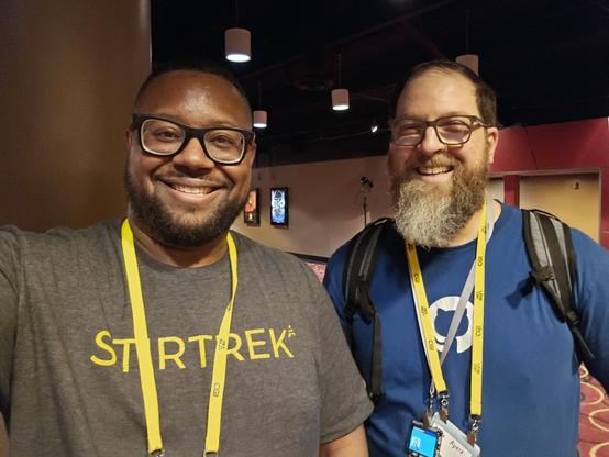 Me wearing a grey shirt with yellow Stirtrek text. Chris wearing a blue GitHub shirt