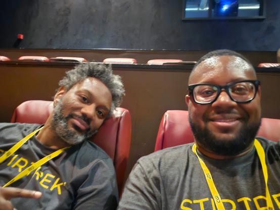 Jon and I relaxing in theater seating wearing StirTrek shirts