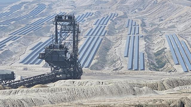 Solarzellen im Tagebau, im Vordergrund ein Absetzer. alles sieht aus wie eine Dystrophie der Ausbeutung der Rohstoffe auf einem anderen Planeten.