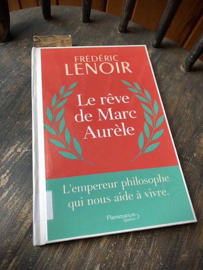 Un livre emprunté à la BAnQ : Le rêve de Marc Aurèle, de Frédéric Lenoir sur fond rouge et turquoise avec deux feuilles de laurier formant une couronne autour du titre.