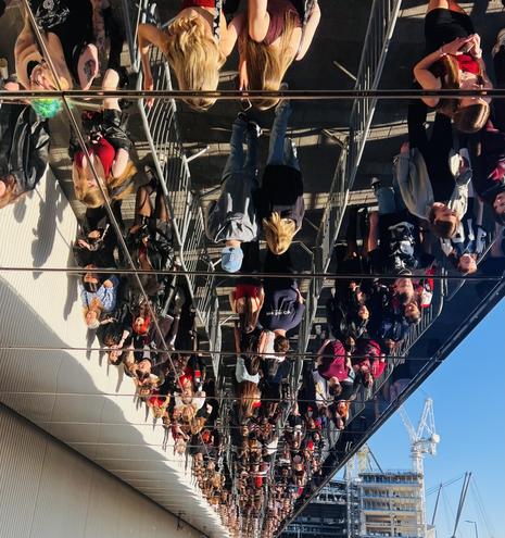 A queue for a concert as seen in a mirrored ceiling