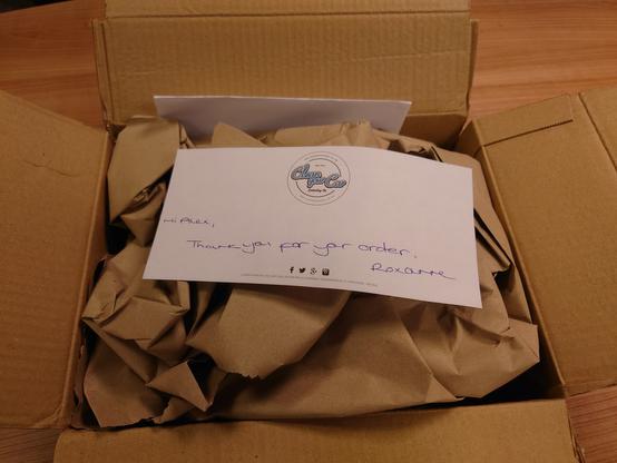 Contents packed with brown paper and bubble wrap, with handwritten thank you note from a member of staff
