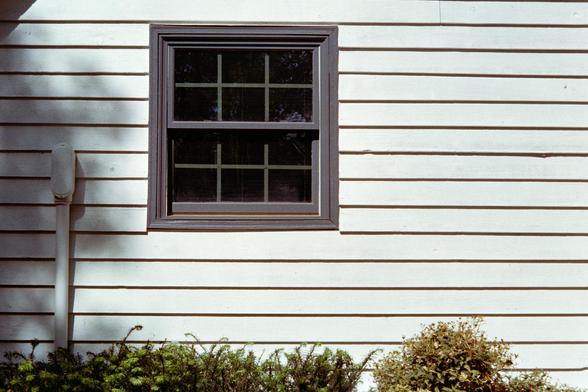A dark window on a white exterior wall