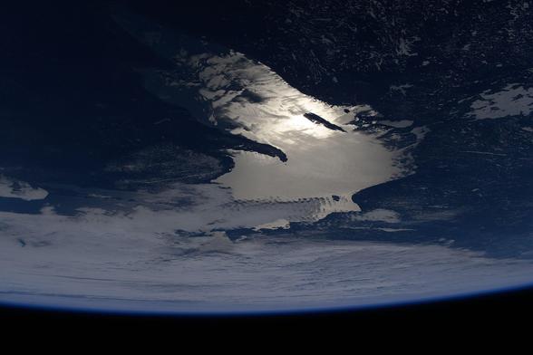 Oblique_of_view_of_the_sun's_glint_beaming_off_Lake_Superior_(iss073e0006003).jpg