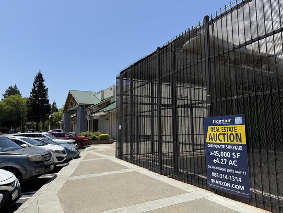Empty OSH building on Cattle Rd with an auction sign hanging on a wall.