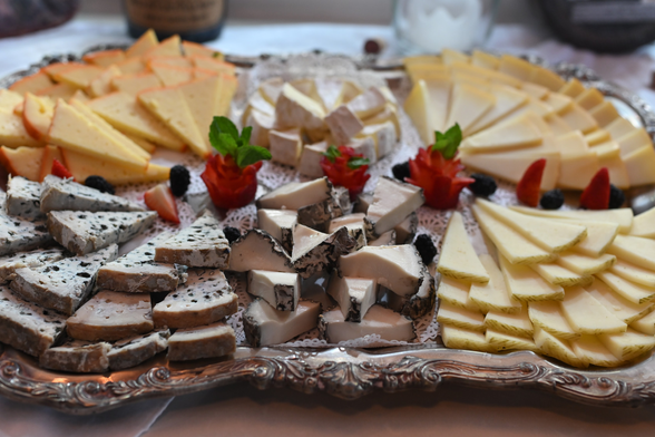 a cheeseboard with piles of 6 different cheeses

CLOCKWISE...
TOP LEFT - Mahón - orange, crumbly
TOP CENTER - Lingote Cremoso - like brie on steroids
TOP RIGHT - Idiazábal - pale yellow
BOTTOM LEFT - Valdeón - coarse / strong / creamy blue
BOTTOM CENTER - Montenebro - very soft & creamy w/ black mold on the outside (of course you eat it)
BOTTOM RIGHT -Manchego - pale yellow firm with a darker rind