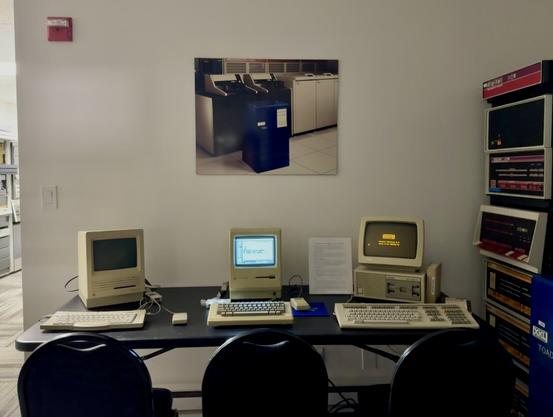 A group of vintage computers on a table.
