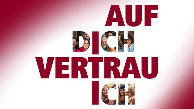 Das Motto der Konferenztagung steht in Großbuchstaben auf weißem Hintergrund. Das Wort »VERTRAU« bildet dabei den Querbalken eines Kreuzes. Die Vertikale des Kreuzes entsteht aus den Vokalen der Wörter »DICH« und »ICH«.