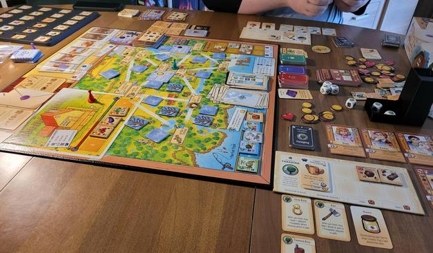 The board game mid game on the table. Very colorful and a lot going on.