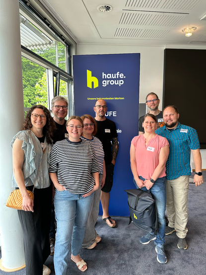 people from the haufe group in front of a glowing logo pixlip thingie