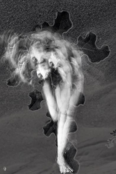 Black and white, portrait format, multiple exposure. The bright silhouette of a person who appears to consist only of several legs terminating in a foot and a head, moving, blurred, and double-exposed with the oversized leaf of a bitter gourd. The background appears grainy (desert sand on which the leaf lies). The overall impression is strange, an alien-like cephalopod creature. Alone with itself and yet not alone because of the three heads.