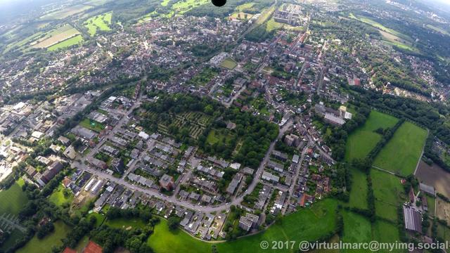 A photo of a city from above, this is Herten Westholt. A green cementry can be seen in the middle of the city.