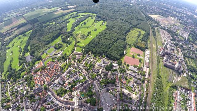 A photo from Herten Westholt from above. Some woods and a golf course can be seen in the front. The Westerholt mine can be seen at the right.