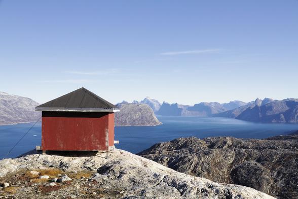 a hunting cabin in the mountains of greenland in the morning