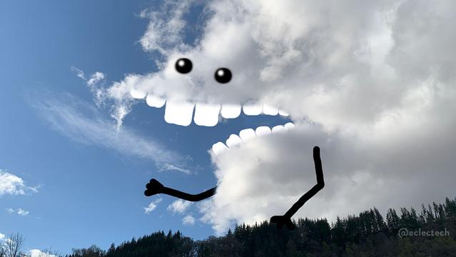 A photo of a fluffy white cloud against a blue sky, sitting above a wooded hillside. There is an indent in the cloud, that I have interpreted as a jaw, adding big square white teeth, eyes above, and arms below. They look pleased to see you.