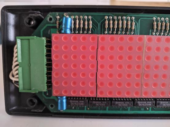 picture of the top layer board, featuring some 5x7 LED matrices, a big clunky connector, lots of resistors and a row of ICs.

you can start to see some light corrosion on the board