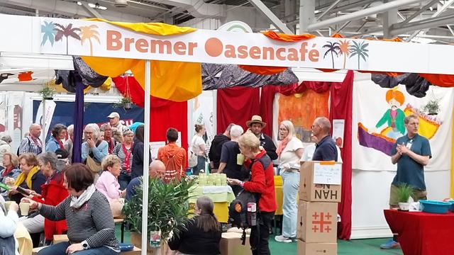 Der bunte Stand des Bremer Oasencafes lädt Menschen zum Verweilen ein.