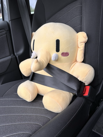 A mastodon plushy in a car seat with seat belts on