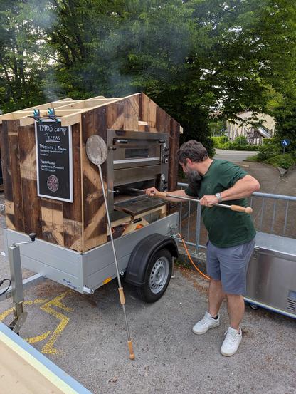 Andri als Pizzaiolo vor selbstgebautem mobilem Pizzaofen.