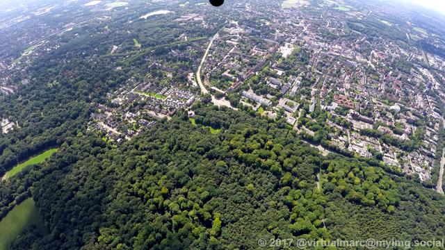 An aerial photo of Gelsenkirchen Buer (and part of Erle) behind green woods.
