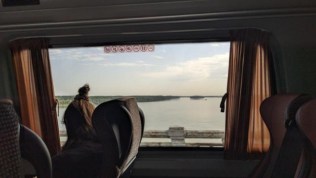 Picture of a mini bus windows with the sight of the Danube Friendship Bridge.