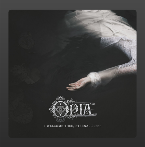 The album cover for I Welcome Thee, Eternal Sleep by Opia features a haunting and ethereal scene. A figure dressed in a delicate, white lace gown floats motionless in dark, still water. Only part of the body is visible—an arm with an open hand, pale and slightly red-stained, reaches outwards. The water surrounding the figure is deep black, evoking a sense of quiet finality and mystery. The band’s name, Opia, appears in ornate, gothic lettering with an eye motif integrated into the design. Below it, the album title is written in a solemn serif font: I Welcome Thee, Eternal Sleep. The overall mood is melancholic, eerie, and introspective, hinting at themes of death, surrender, and peace.