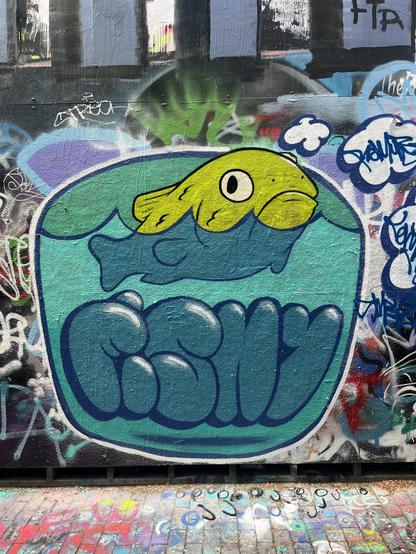 A large, colorful, street-level mural of a goofy looking fish in a fishbowl, glowering at you uncertainly. Big graffiti-style balloon letters on the bowl spell “FISHY”.