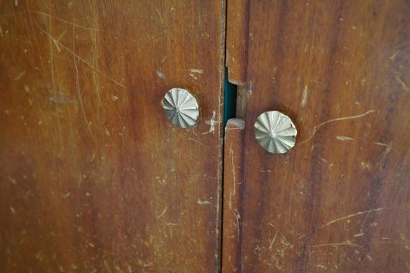 Two light coloured brass looking flowery handles. put where the keyholes used to be. The rest of the doors are still well worn.