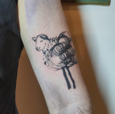 Sheep tattoo on an upper arm